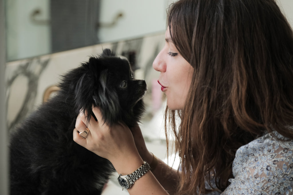 woman kissing her black dog