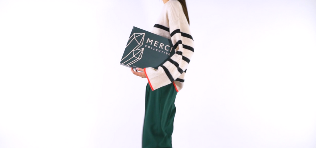 woman walking holding merci collective packaging